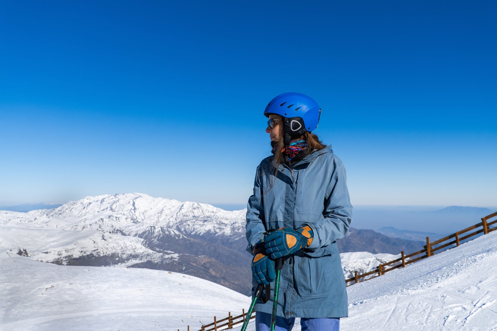 A,Woman,In,Snow,Attire,Stands,On,A,Snowy,Mountain,